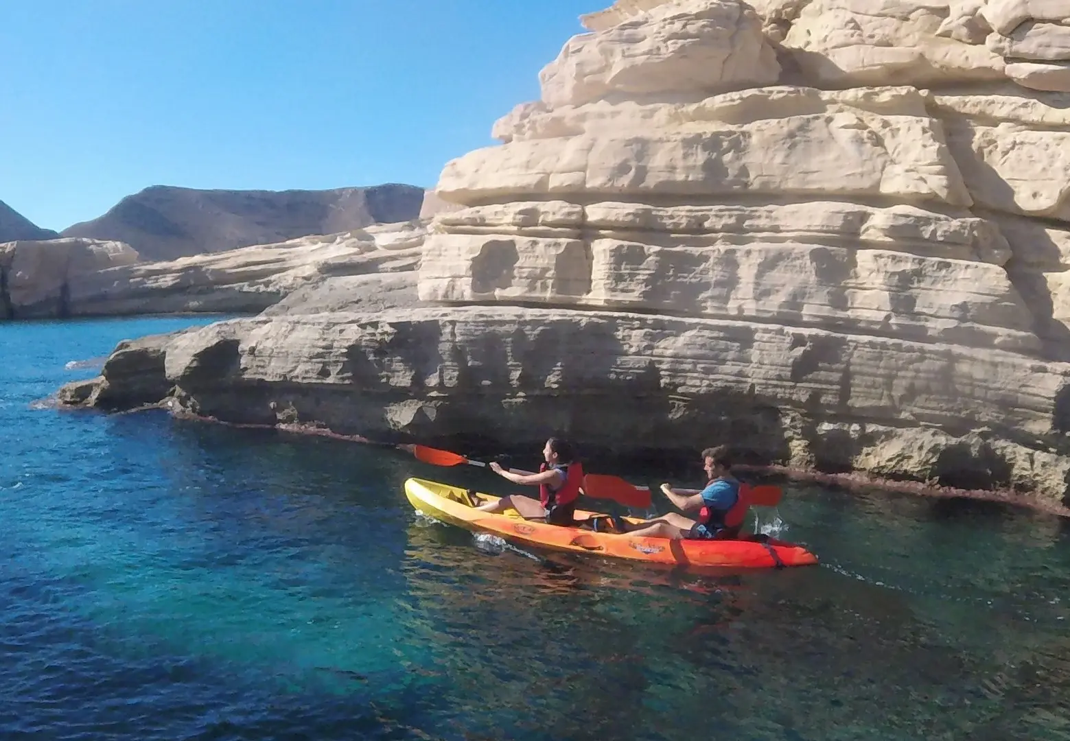 Costa volcánica de Los Escullos, Cabo de Gata, vista desde un kayak – acantilados negros y agua turquesa